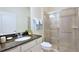 Bright bathroom showcasing a granite vanity with ample counter space and a glass-enclosed shower at 1663 Lima Ave, Kissimmee, FL 34747