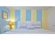 Bedroom featuring striped accent wall, white bed frame, and blue and white striped bedding at 1663 Lima Ave, Kissimmee, FL 34747