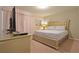 Bedroom featuring a queen bed with gold frame, neutral bedding, a TV, and soft pink curtains at 1663 Lima Ave, Kissimmee, FL 34747