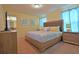 Bedroom featuring a wooden bed frame, yellow bedding, and blue patterned curtains at 1663 Lima Ave, Kissimmee, FL 34747