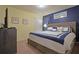 Bright bedroom featuring a queen bed with blue and white bedding, framed artwork, and closet at 1663 Lima Ave, Kissimmee, FL 34747