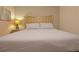 Bedroom featuring a queen bed with neutral bedding, lamp on bedside table, and soft lighting at 1663 Lima Ave, Kissimmee, FL 34747