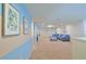 Spacious living room boasts plush carpet, blue sectional sofa, and open layout at 1663 Lima Ave, Kissimmee, FL 34747