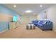 Bright living room featuring a blue sectional, striped ottoman, and neutral carpet at 1663 Lima Ave, Kissimmee, FL 34747