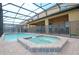 Backyard pool and spa area with screened-in enclosure and lake views, ideal for outdoor enjoyment at 1663 Lima Ave, Kissimmee, FL 34747