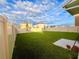 Spacious backyard, bordered with white fencing, features a manicured lawn and a concrete patio at 1800 Post Oak Dr, Davenport, FL 33837