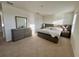 Bright main bedroom featuring neutral tones, carpet, and a large dresser at 1800 Post Oak Dr, Davenport, FL 33837