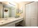 Bathroom vanity with large mirror, tile countertop, white cabinets, and decorative flowers at 200 Maitland Ave # 224, Altamonte Springs, FL 32701