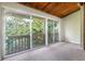 Cozy living room featuring sliding glass doors to the balcony and unique wood-beamed ceiling at 200 Maitland Ave # 224, Altamonte Springs, FL 32701