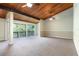 Spacious living room with carpet, wood-beamed ceilings, ceiling fans, and sliding glass doors at 200 Maitland Ave # 224, Altamonte Springs, FL 32701