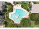 Aerial view of a unique, geometric-shaped pool surrounded by lush landscaping and lounge chairs at 200 Maitland Ave # 224, Altamonte Springs, FL 32701
