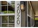 Close up of house numbers '2020' attached to side of the home with exterior lighting at 2020 Palmer St, Orlando, FL 32803