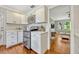 Cozy kitchen features stainless appliances, white cabinetry, and hardwood floors that connect to the living area at 2020 Palmer St, Orlando, FL 32803