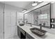 The bathroom features a modern vanity with dual sinks, a large mirror and black and white tile at 203 E Greentree Ln, Lake Mary, FL 32746