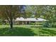 Charming single story home with a metal roof, brick accents, and mature landscaping in a park-like setting at 203 E Greentree Ln, Lake Mary, FL 32746