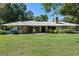 Charming home boasts metal roof, brick accents, and mature landscaping on a manicured lawn at 203 E Greentree Ln, Lake Mary, FL 32746