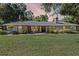 Charming single-story home with brick and white siding, a metal roof, and a well-manicured front lawn at 203 E Greentree Ln, Lake Mary, FL 32746