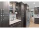 Kitchen featuring dark wood cabinets, stainless appliances, and white countertops with patterned backsplash at 203 E Greentree Ln, Lake Mary, FL 32746
