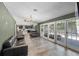 Spacious living room with wood-look tile, open floor plan, and views of kitchen and outdoor patio at 203 E Greentree Ln, Lake Mary, FL 32746
