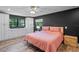 This main bedroom features an ensuite bathroom, white cabinets, wood floors and a ceiling fan at 203 E Greentree Ln, Lake Mary, FL 32746
