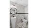This powder room has marble walls, a pedestal sink, round mirror, and modern fixtures at 203 E Greentree Ln, Lake Mary, FL 32746