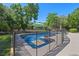 Beautiful swimming pool with an umbrella, surrounded by lush landscaping and a -proof fence at 203 E Greentree Ln, Lake Mary, FL 32746
