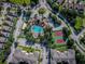 Aerial view of community featuring a pool, tennis courts, lush landscaping, and manicured lawns at 2302 Butterfly Palm Way # 105, Kissimmee, FL 34747