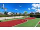 Community basketball court with green and red surface and a perimeter fence; lush landscaping nearby at 2302 Butterfly Palm Way # 105, Kissimmee, FL 34747