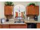 Cozy kitchen featuring granite countertops, cabinets, stainless steel appliances, and a view of the living room at 2302 Butterfly Palm Way # 105, Kissimmee, FL 34747