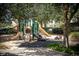 Community playground with slides, climbing structures, and shade trees at 2302 Butterfly Palm Way # 105, Kissimmee, FL 34747
