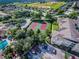 Aerial view of community tennis courts, surrounded by lush landscaping, located near the pool and parking at 2302 Butterfly Palm Way # 105, Kissimmee, FL 34747