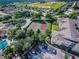 Aerial view showcasing the tennis courts, pool, and surrounding lush landscaping of the community at 2302 Silver Palm Dr # 203, Kissimmee, FL 34747