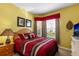Inviting bedroom with warm colors, a comfortable bed, and a window offering natural light at 2302 Silver Palm Dr # 203, Kissimmee, FL 34747