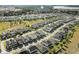 Panoramic aerial view of a thriving community with diverse home styles, lush landscaping, and a serene lake in the distance at 2405 Standing Rock Cir, Oakland, FL 34787