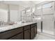 Modern bathroom featuring dual sinks, granite countertops, and a glass-enclosed shower at 2405 Standing Rock Cir, Oakland, FL 34787