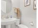 Clean and modern bathroom with a pedestal sink, round mirror, and neutral decor at 2405 Standing Rock Cir, Oakland, FL 34787