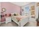 Bright bedroom featuring stylish decor, a pink accent wall, and a cozy atmosphere at 2405 Standing Rock Cir, Oakland, FL 34787