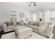 Cozy living room showcasing neutral tones, large windows, comfortable sofas, and a ceiling fan at 2405 Standing Rock Cir, Oakland, FL 34787