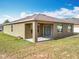Exterior of the home with a patio and a well-manicured lawn at 2636 Grand Central Ave, Tavares, FL 32778