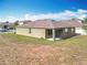 View of the home's backyard with a covered patio, grassy areas, and partial perimeter fencing at 2636 Grand Central Ave, Tavares, FL 32778