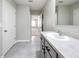 Bathroom with marble vanity, single sink, neutral gray walls, gray tile flooring, and large mirror at 2636 Grand Central Ave, Tavares, FL 32778