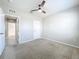 Bright bedroom with neutral carpet, ceiling fan, and a view of the hallway at 2636 Grand Central Ave, Tavares, FL 32778