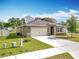 Attractive single-story home with green lawn, clean driveway, and an attached two-car garage at 2636 Grand Central Ave, Tavares, FL 32778