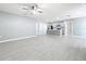 Open concept living room with ceiling fan, light gray walls, and gray wood-look tile floors throughout at 2636 Grand Central Ave, Tavares, FL 32778
