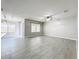 Large living room with natural light, ceiling fan, and gray wood-look tile floors throughout at 2636 Grand Central Ave, Tavares, FL 32778