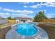 Aerial view of backyard featuring kidney-shaped pool with blue tiles, screened patio, and fenced perimeter at 2763 E Waco Dr, Deltona, FL 32738
