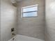 Bathroom with tiled walls around a tub and shower, offering a stylish and durable design at 2763 E Waco Dr, Deltona, FL 32738