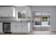 Bright kitchen featuring white cabinets, granite countertops, and a stainless steel dishwasher at 2763 E Waco Dr, Deltona, FL 32738