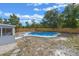 Backyard featuring a kidney-shaped pool, stone patio, wood fence, and screened-in porch at 2763 E Waco Dr, Deltona, FL 32738