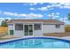 Poolside view of an enclosed porch and steps leading to the refreshing backyard pool at 2763 E Waco Dr, Deltona, FL 32738